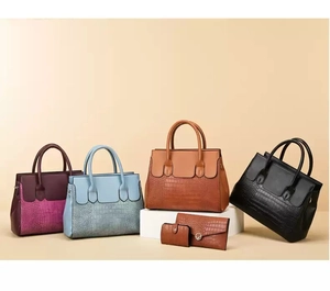 Detail view of crocodile pattern leather handbags and matching wallets set in various colors