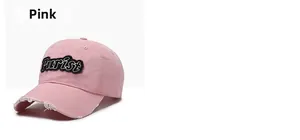 Detailed close-up of pink washed cotton baseball cap with distressed brim and Purist patch