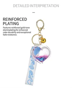 Detail view of heart-shaped quicksand keychain with golden bell and blue ribbon strap