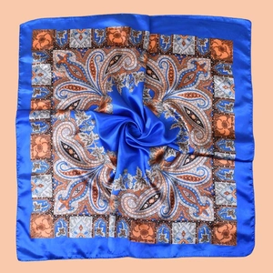 Detailed view of paisley silk scarf texture with navy blue border and brown patterns