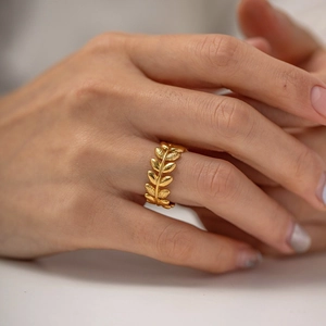 Elegant gold olive leaf open ring in stainless steel worn on a finger for women