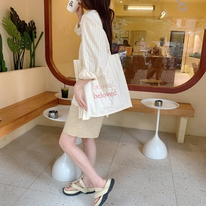 Gros plan du sac en toile blanche avec broderie beloved et logo de marque b.write