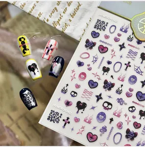 Macro view of gothic punk nail art stickers with skulls hearts and butterfly motifs