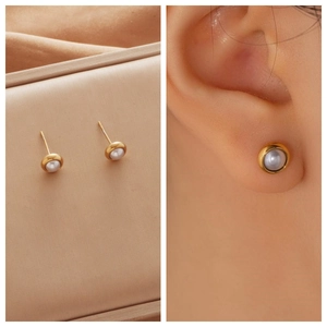 Detailed view of pearl earrings with gold-plated edges on model and in jewelry box