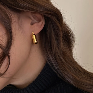 Detail shot of irregular gold geometric earring with high-shine mirror finish