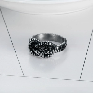 Macro detail of retro silver stainless steel ring featuring a knotted rope texture design