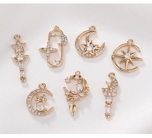 Detailed view of gold-plated copper star and moon charms with inlaid zircon for DIY jewelry