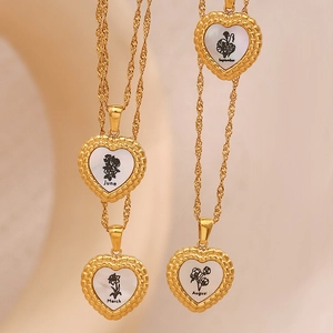 Détail du collier cœur doré avec incrustation de nacre et motif de fleur de naissance
