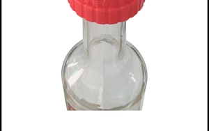 Close-up of red silicone wine stopper in a little red riding hood hat shape on a glass bottle
