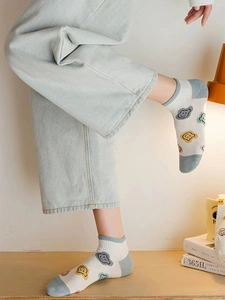 Close-up of white cotton ankle socks with cute colorful bear patterns and blue heels