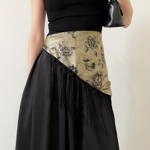Macro shot of bronze gold fabric belt with black rose prints and long fringe tassels