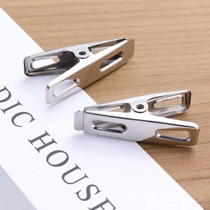 Macro detail of high-quality stainless steel windproof pegs on a minimalist wooden surface