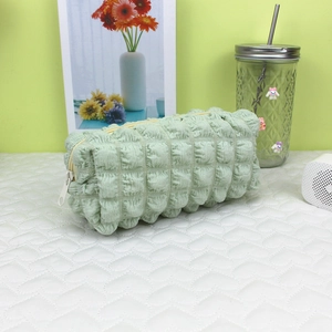 Macro detail of mint green puffy textured pencil case with secure zipper closure