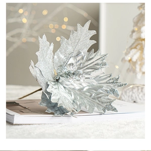 Detailed close-up of sparkling silver artificial leaves on books for Christmas decor