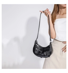 Détail du sac demi-lune noir de style punk avec fermetures éclair et boucles en métal