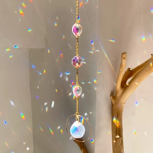 Close-up of crystal suncatcher with golden ring and faceted prism reflecting rainbow light