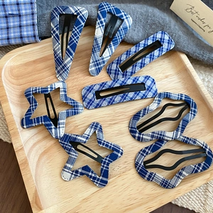 Close-up of blue plaid fabric hair clips in star and geometric shapes on a tray