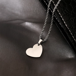 Close-up of a polished stainless steel heart pendant on a twisted rope chain necklace