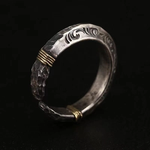 Macro shot of vintage silver arrowhead ring with golden wire and carved relief texture