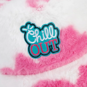 Detail of plush cow print bucket hat with blue Chill OUT embroidered patch