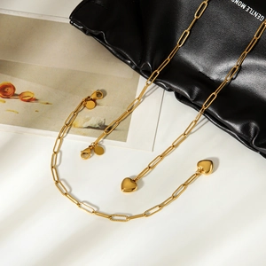 Vue détaillée du collier en acier inoxydable doré avec pendentifs cœur sur sac en cuir
