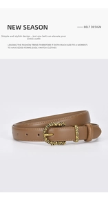 Detail of a brown leather belt featuring an intricate gold floral embossed metal buckle