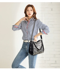 Fashionable zebra print shoulder bag for women styled with casual striped shirt and jeans
