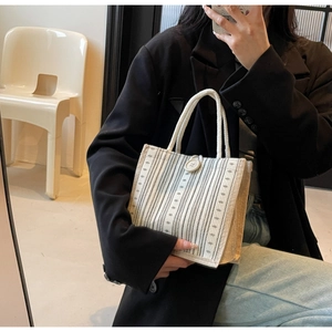 Mirror selfie showing a striped linen tote bag with fabric handles and button detail