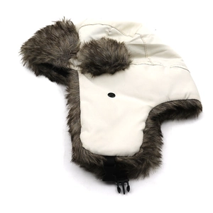 Detailed view of cream trapper hat with thick faux fur lining and black buckle strap