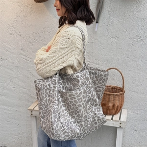 Detailed shot of leopard print canvas tote bag with large front pocket and double handles
