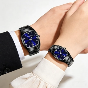 Detail of couple watches with blue rectangular dials and black metal straps worn by models
