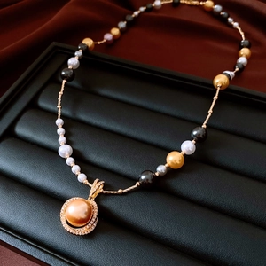 Détail macro d'un collier de perles dorées avec perles mixtes sur plateau en velours noir