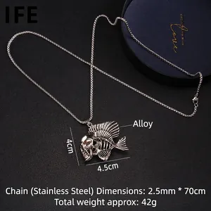 Pendentif squelette de poisson argenté sur chaîne en acier inoxydable sur fond noir