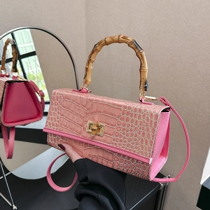 Pink crocodile pattern handbag with bamboo handle and gold twist lock detail