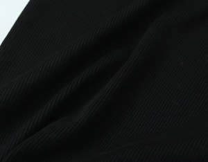 Close-up of black ribbed knit fabric showing high-elasticity texture and soft weave