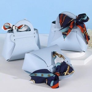 Three light blue PU leather wedding favor bags with decorative floral silk ribbons