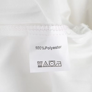 Detail of 100% polyester fabric material with wash care label on a white crop top