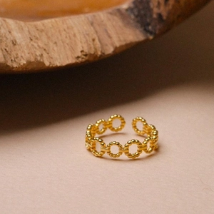 Macro shot of gold beaded chain link ring with adjustable open band for women