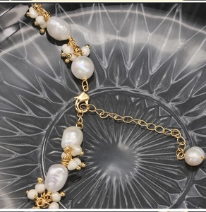 Detailed close-up of a baroque pearl bracelet with gold beads and a lobster clasp