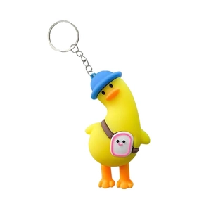 Cute yellow cartoon duck keychain with blue hat and small bag on white background