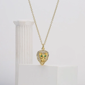 Gold-plated lion head pendant necklace with sparkling cubic zirconia and green gem eyes