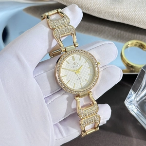Détail macro d'une montre Grealy avec lunette dorée sertie de diamants et cadran