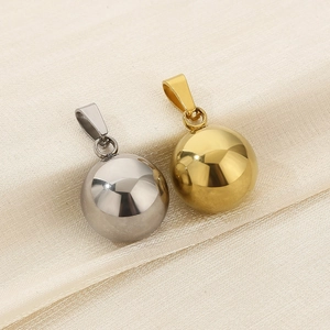 Close-up of gold and silver ball pendants on soft silk fabric with elegant reflection