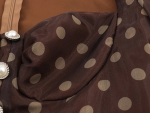 Detail of organza fabric with dots, pearl buttons, and invisible zipper on dress