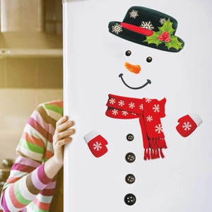 Detailed view of DIY Christmas snowman stickers with carrot nose and scarf on white fridge