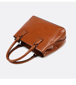 Side view of caramel brown tote bag with high gloss leather texture and metal zipper