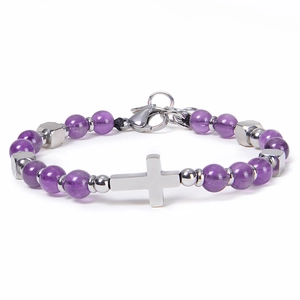 Detailed macro of purple amethyst beads and silver cross charm on stainless steel bracelet
