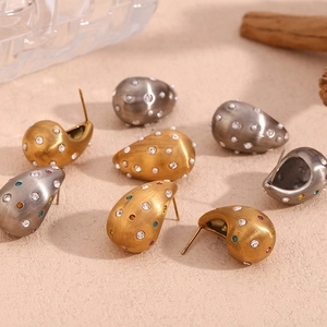 Vue détaillée de boucles d'oreilles gouttes brossées avec cristaux et perles or et argent