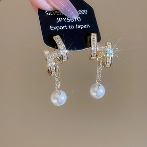 Detailed view of 14K gold plated H-shaped zircon stud earrings with white pearl drops