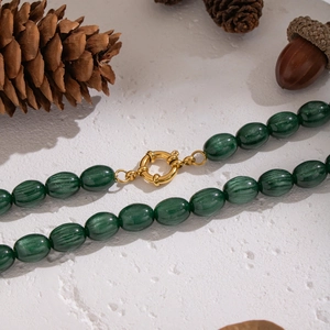 Detail of vintage necklace with green marbled resin beads and golden metallic clasp
